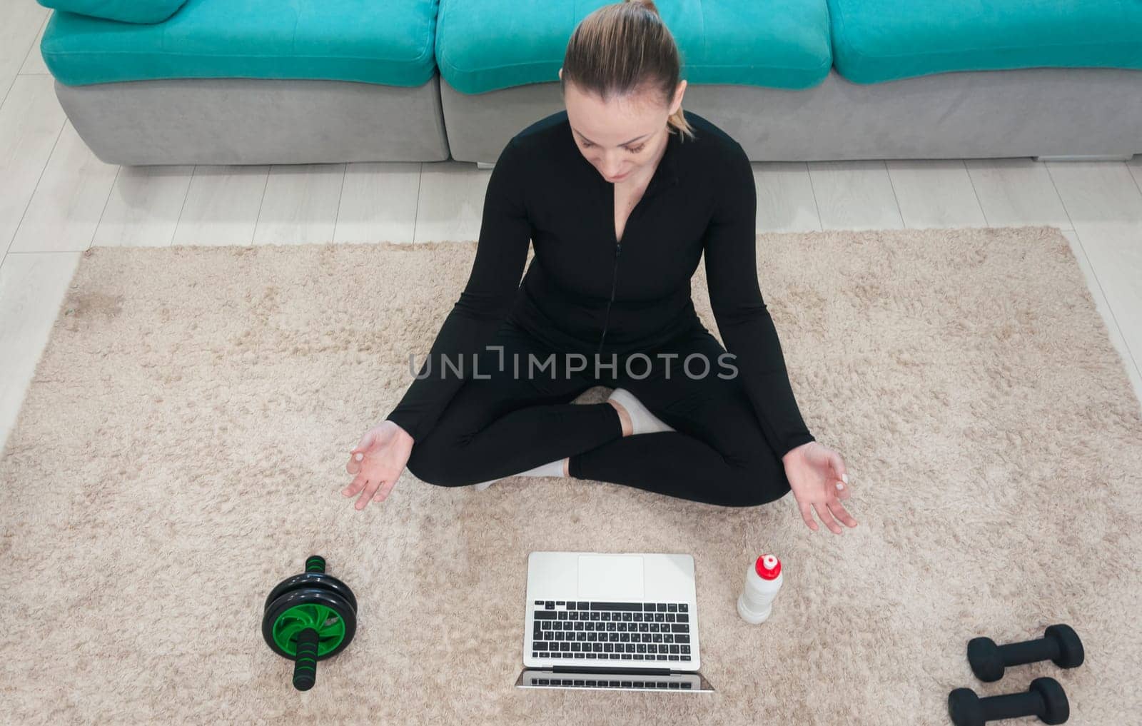 Sporty healthy calm woman sitting on mat in lotus ,wearing uniform by PopOff