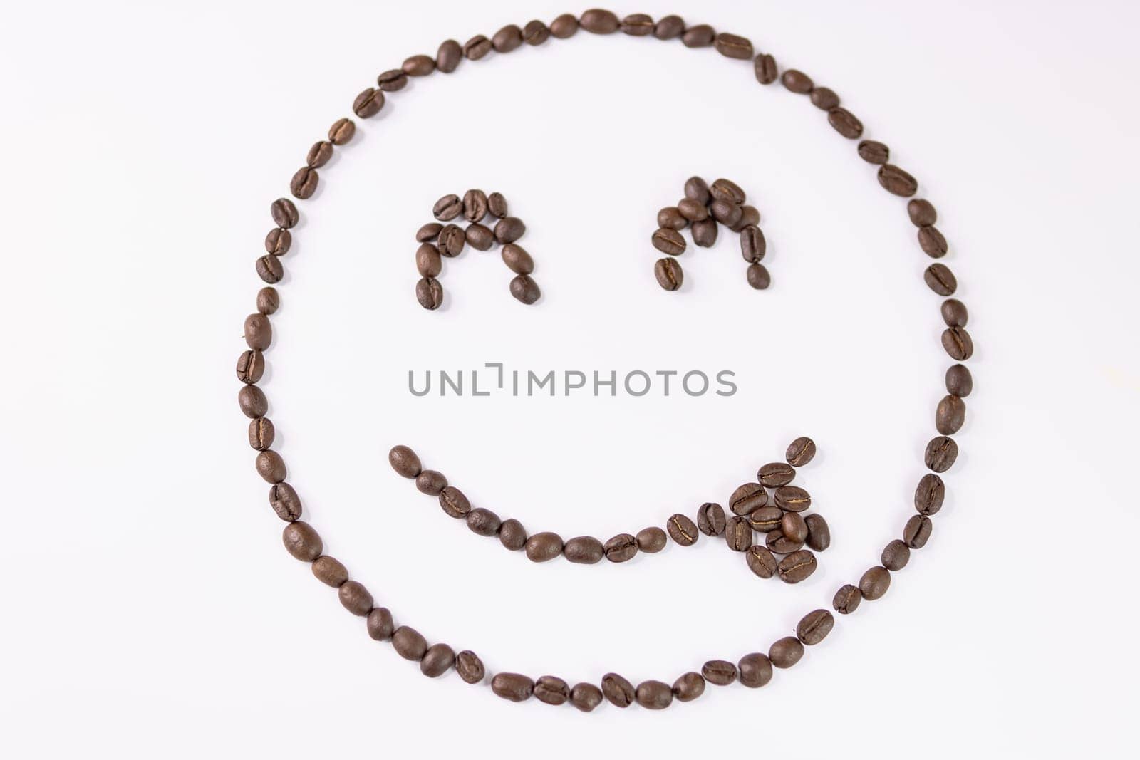 Roasted coffee beans background.Cheerful smiley with coffee beans on a white background. High quality photo