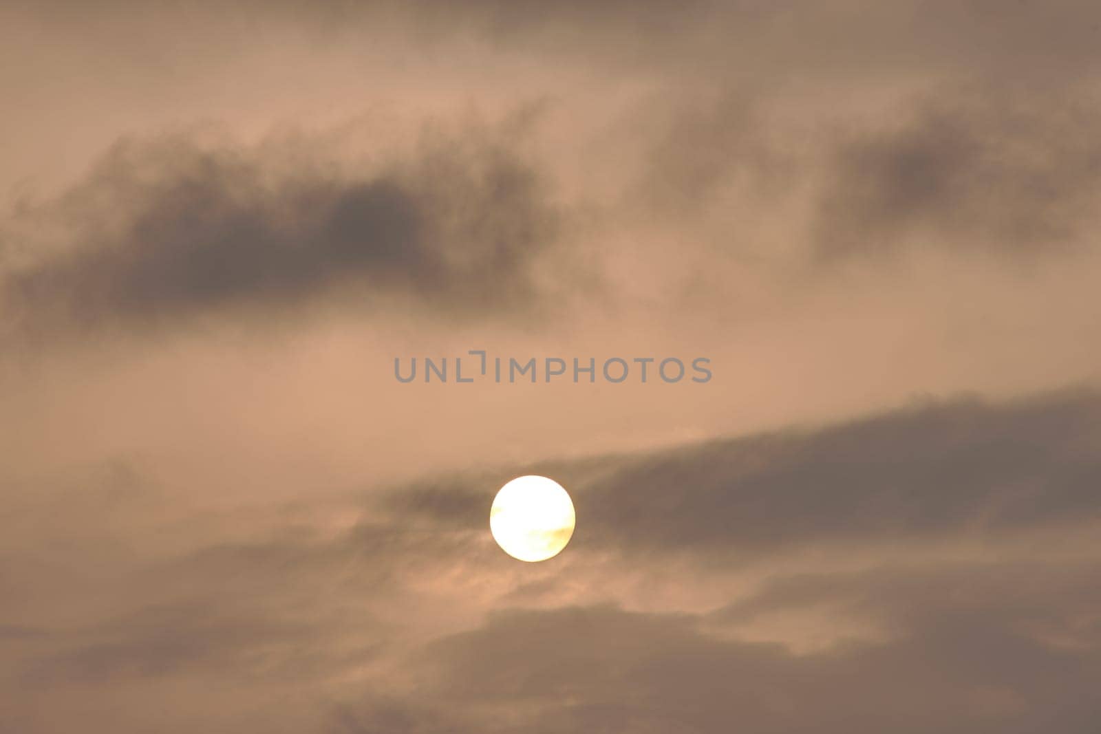Sky, with diffused sun clouds colourful. Dramatic orange sky with a softly obscured sun, surrounded by clouds