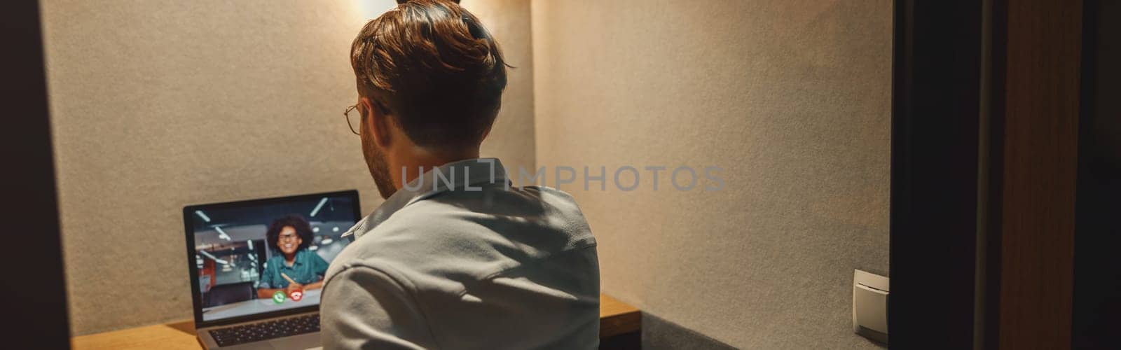 Male freelancer have a videoconference with colleague while sitting in cozy coworking