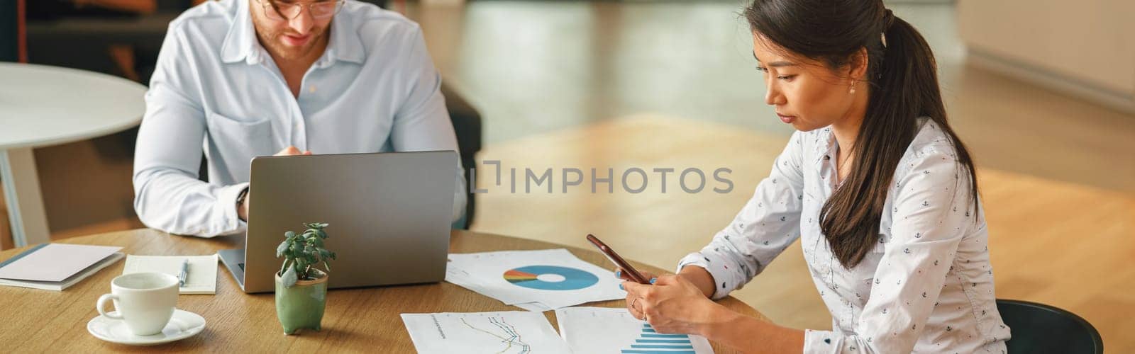 Two business colleagues working with documents together sitting in office.High quality photo