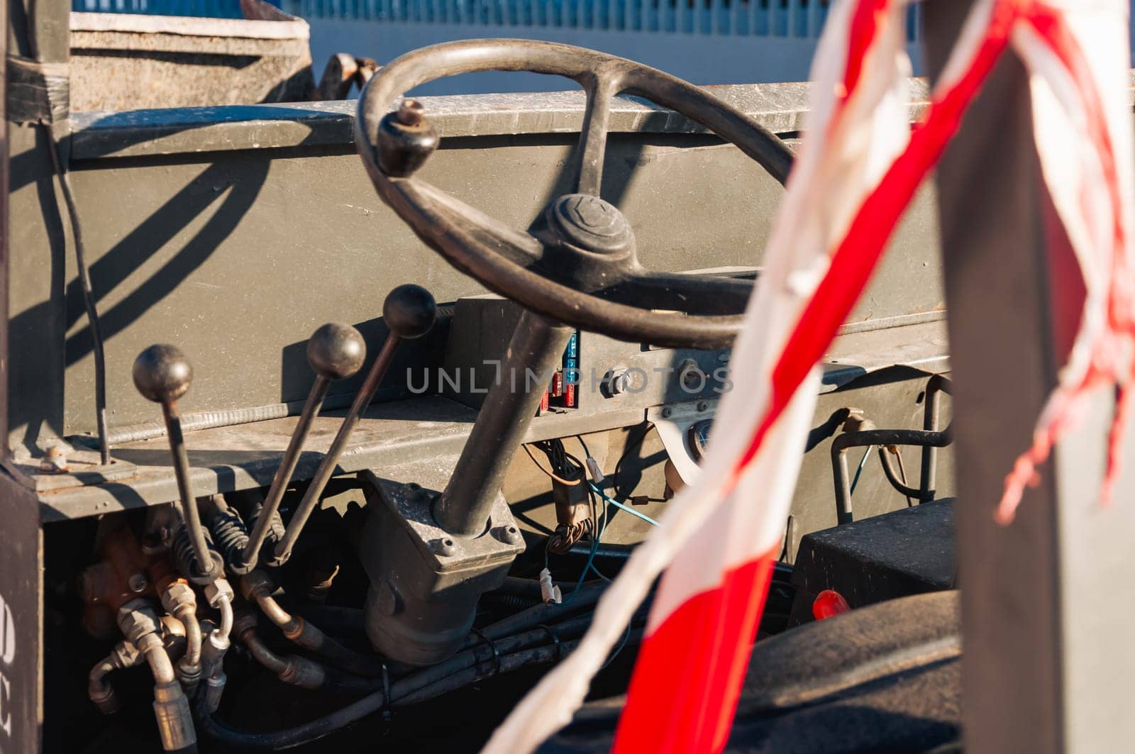 interior of an old tractor in an industrial environment.close-up on the metal parts in the loader on the steering wheel and levers. High quality photo