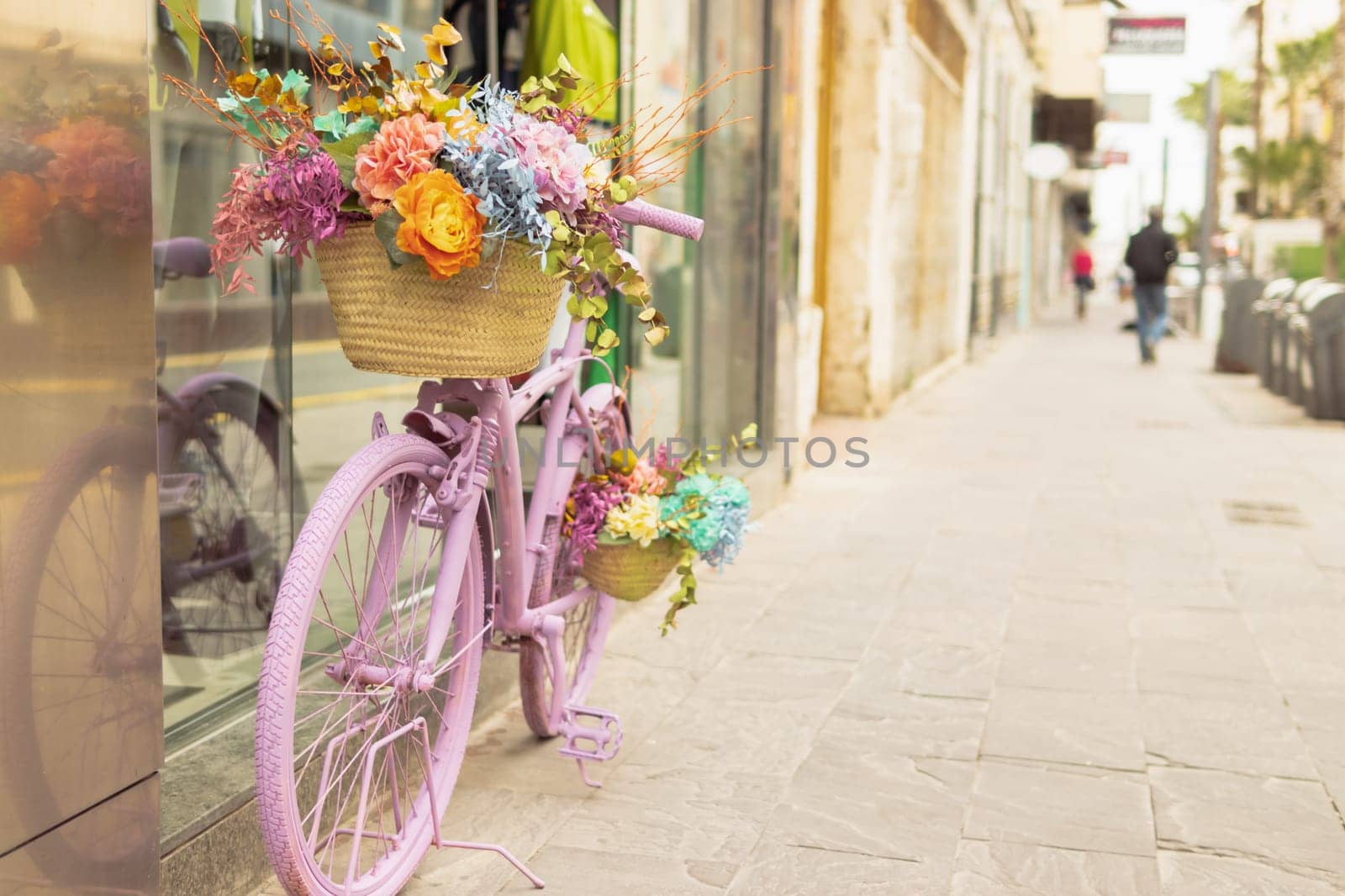 retor bicycle of pink color stands near the shop window decorated with flowers. High quality photo
