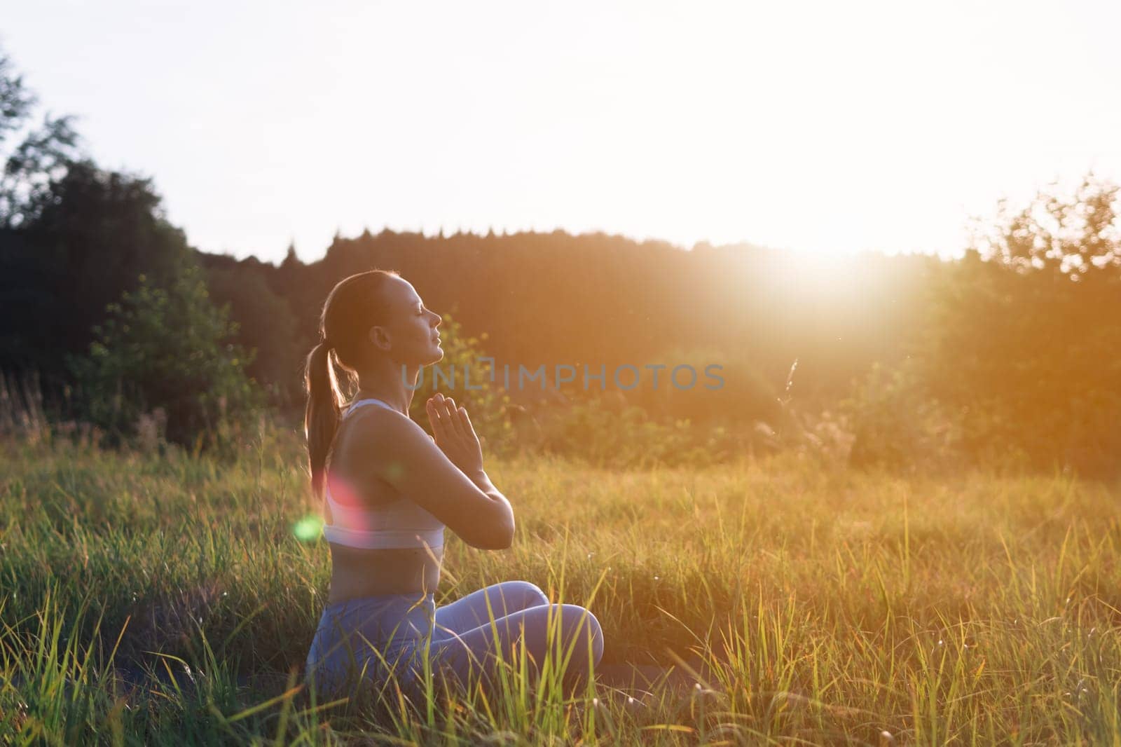 silhouette of a girl of European appearance at sunset, there is a place for an inscription on the side, the girl is doing yoga young girl doing yoga outdoors. High quality photo
