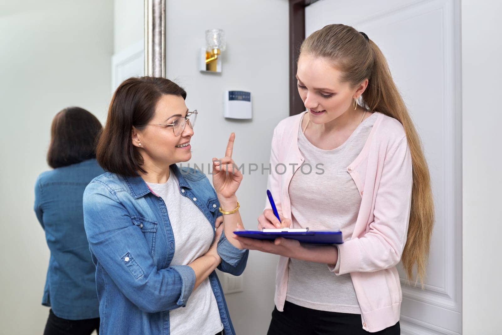Female social worker talking to middle aged woman at home by VH-studio