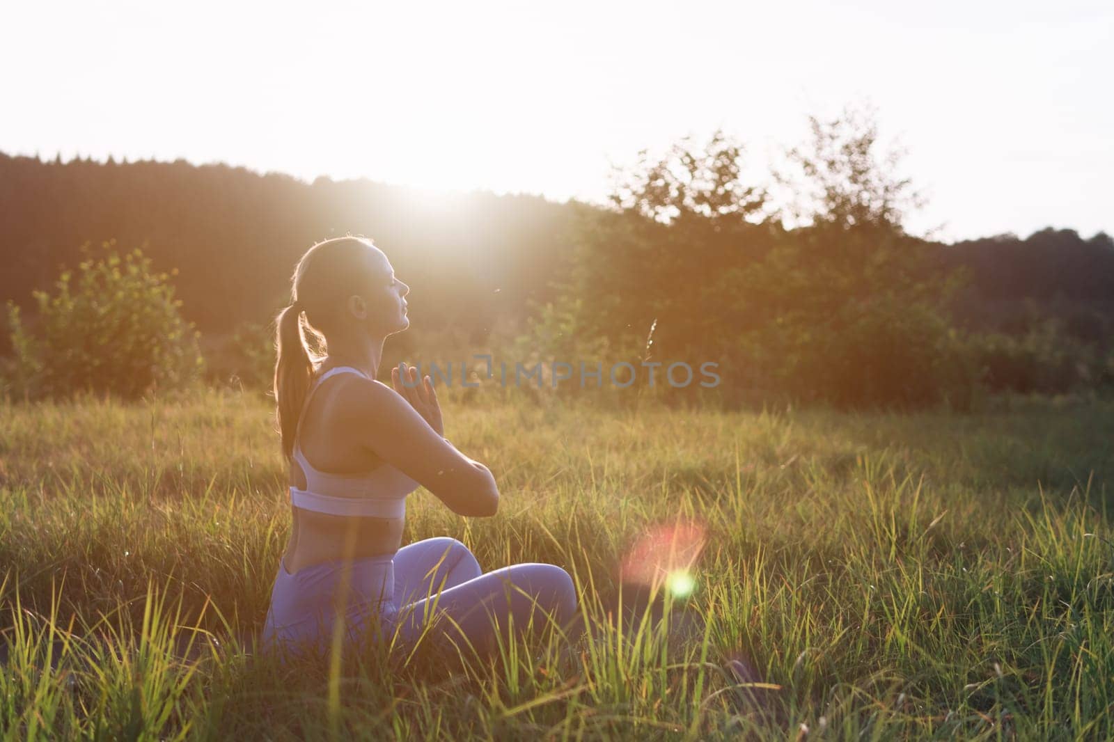 young girl doing yoga outdoors in a suit for fitness. The concept of a healthy lifestyle. there is a place for an inscription. High quality photo