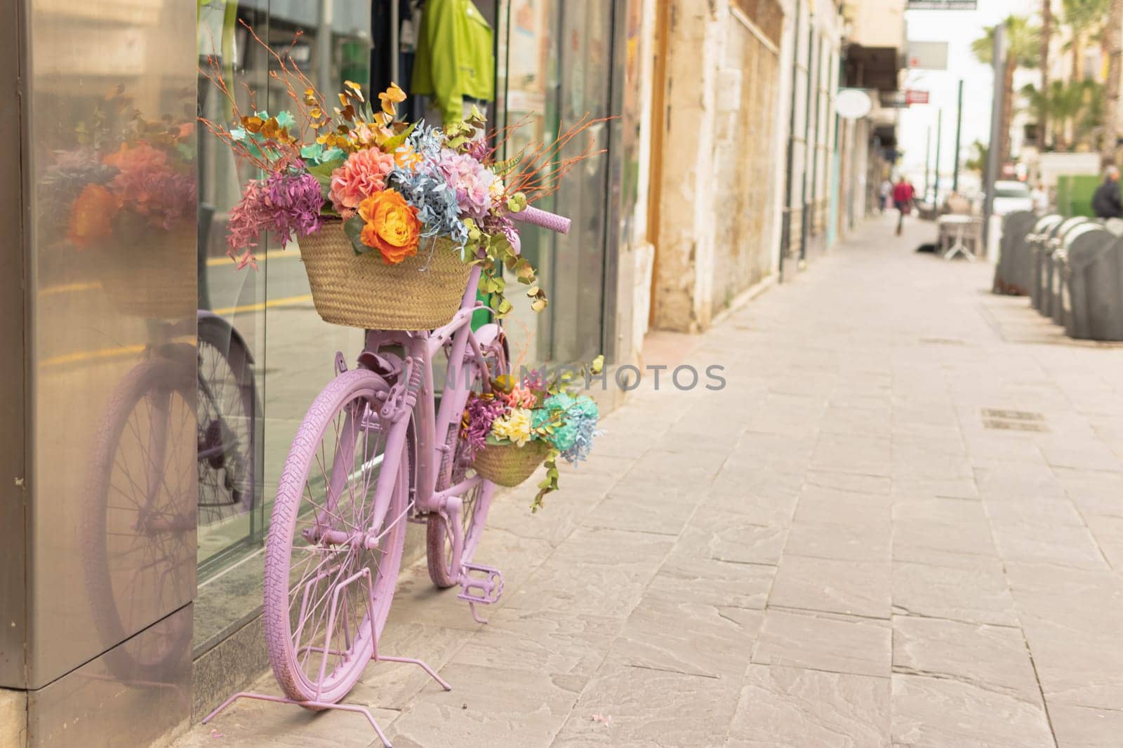 a shop window on the street, near the store there is a pink bicycle decorated with flowers, there is a place for an inscription by PopOff