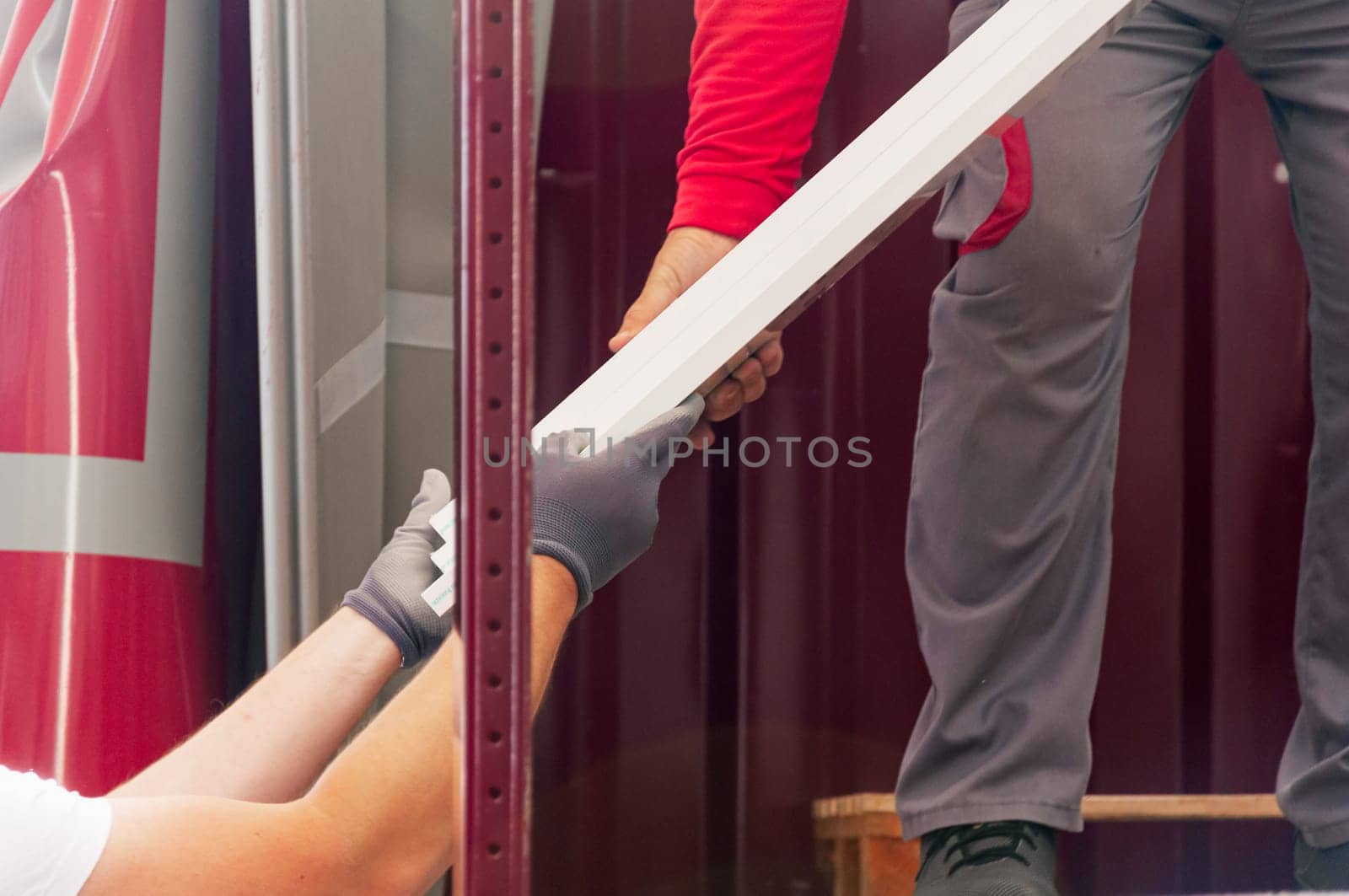 men in working uniform, pass materials to each other, close-up on hands, there is a place for an inscription. High quality photo