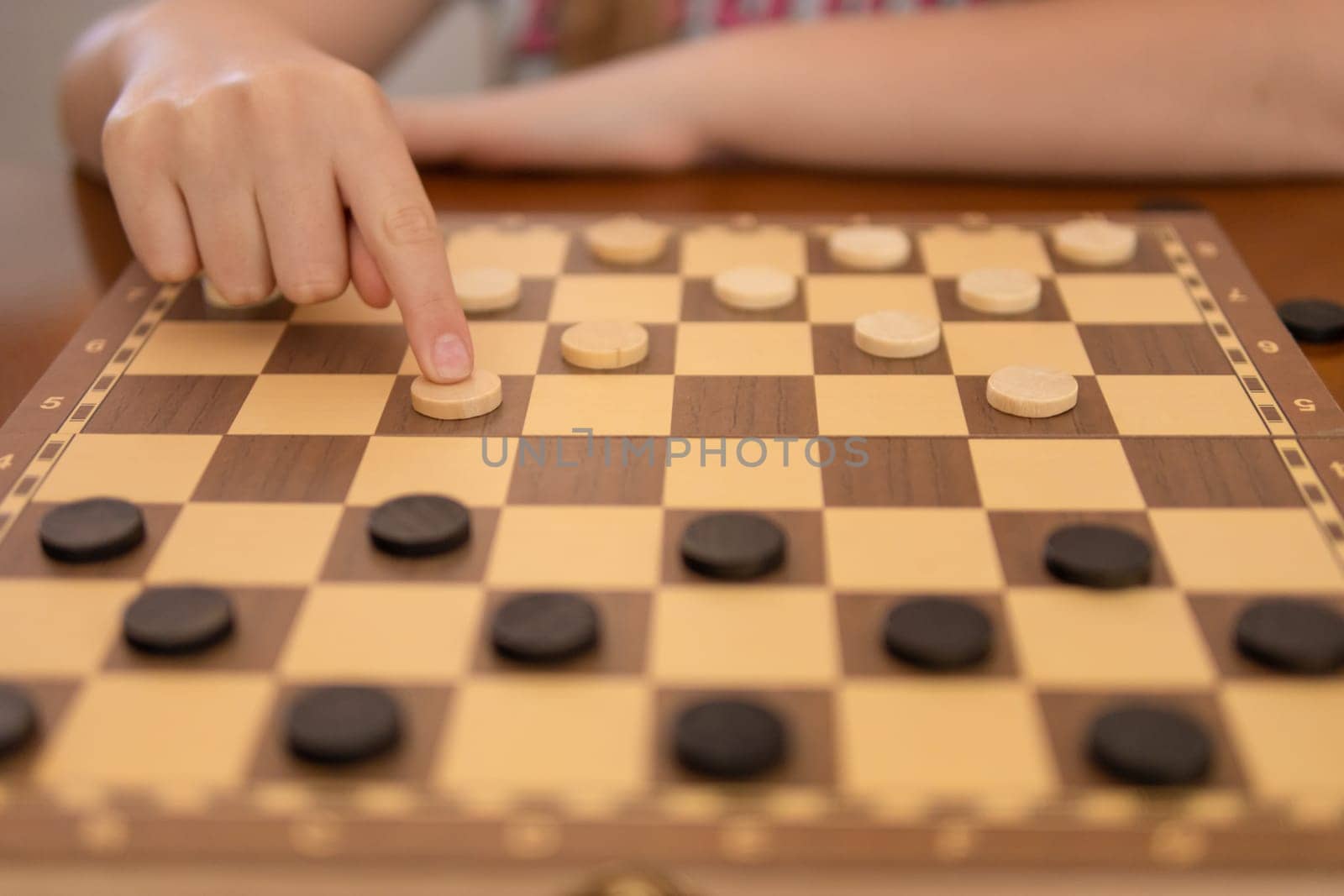 a game of checkers, a woman's hand close-up plays checkers, there is a place for an inscription by PopOff