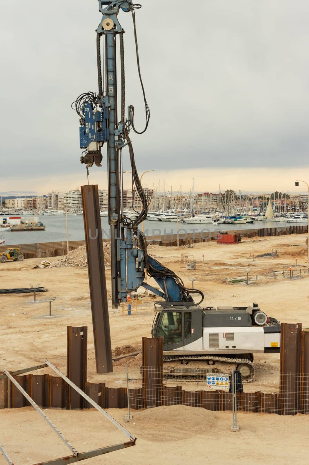 construction site near the pier with yachts, there are a lot of equipment at the construction site, various cranes and cars are standing by PopOff