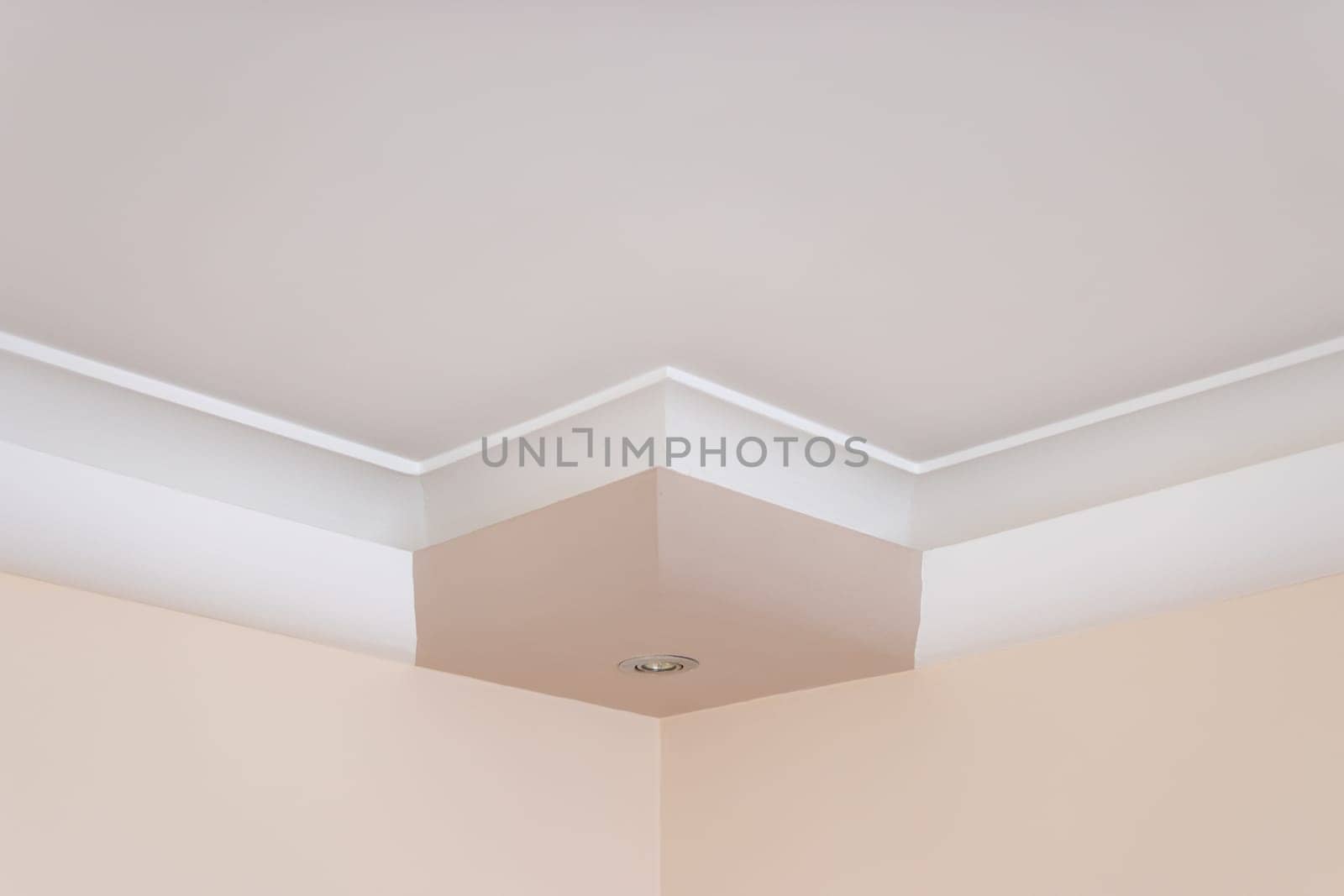 Ornamental white molding decor on the ceiling close-up detail of a white room. The concept of repair and construction of the interior.Close-up. High quality photo