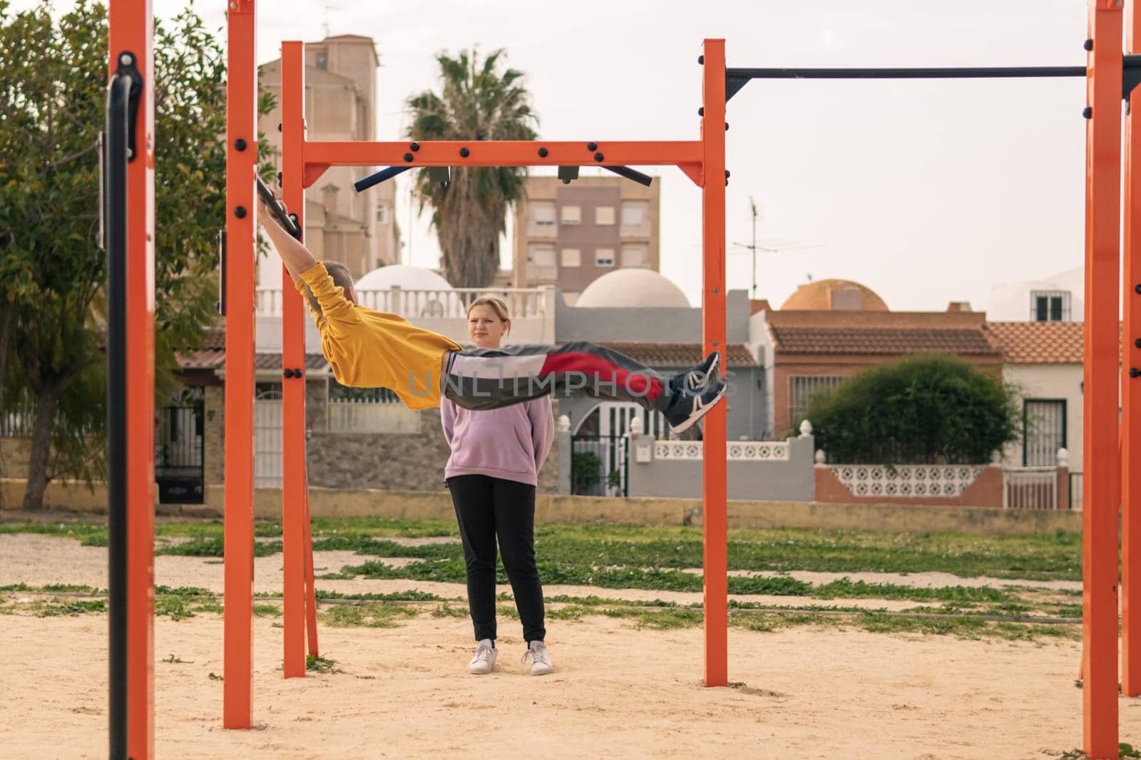 A boy and a girl are teenagers on the playground in the park go in for sports. by PopOff