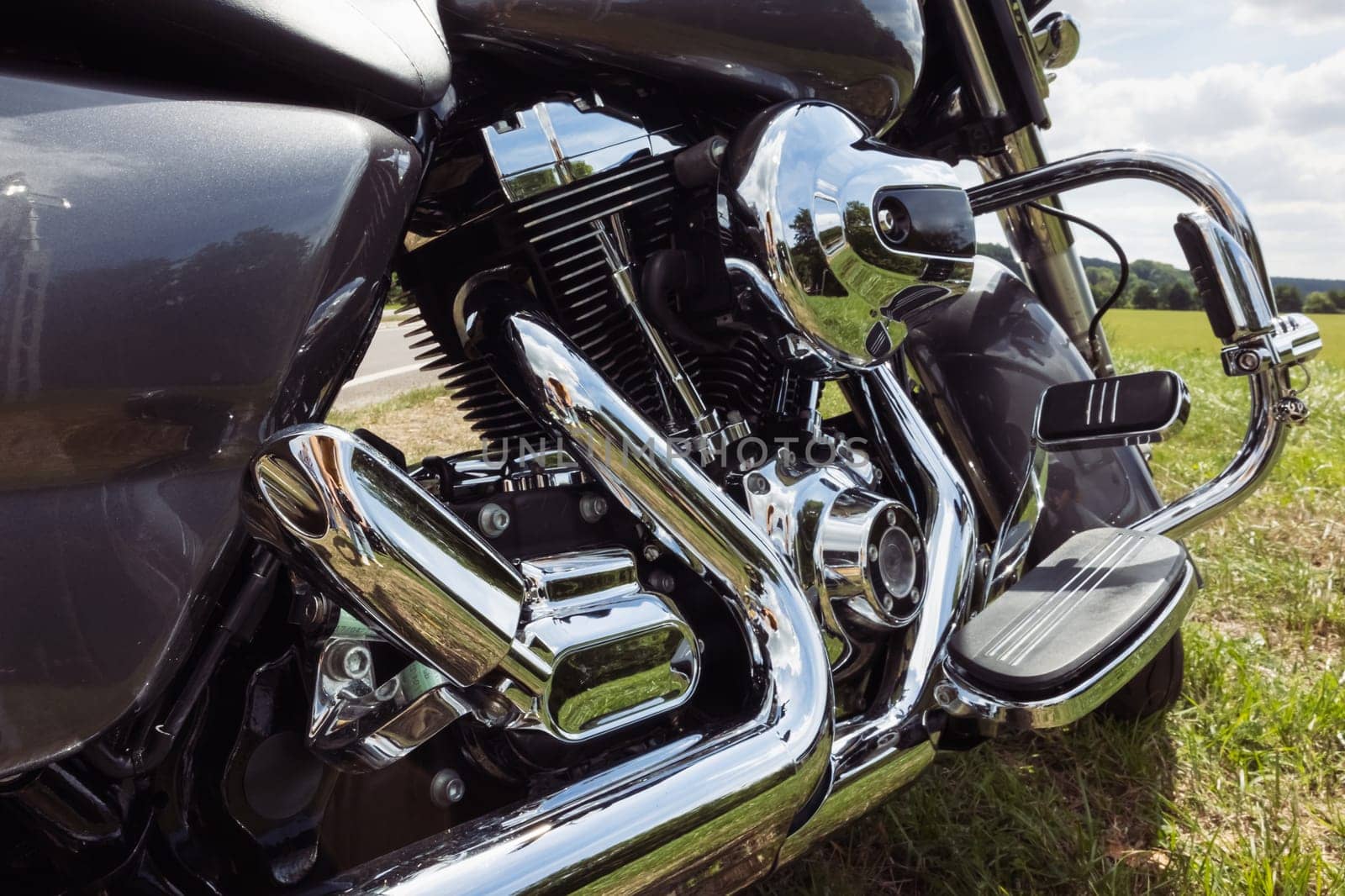 black motorcycle side view close-up ,motorbike stands on green grass isolated by PopOff