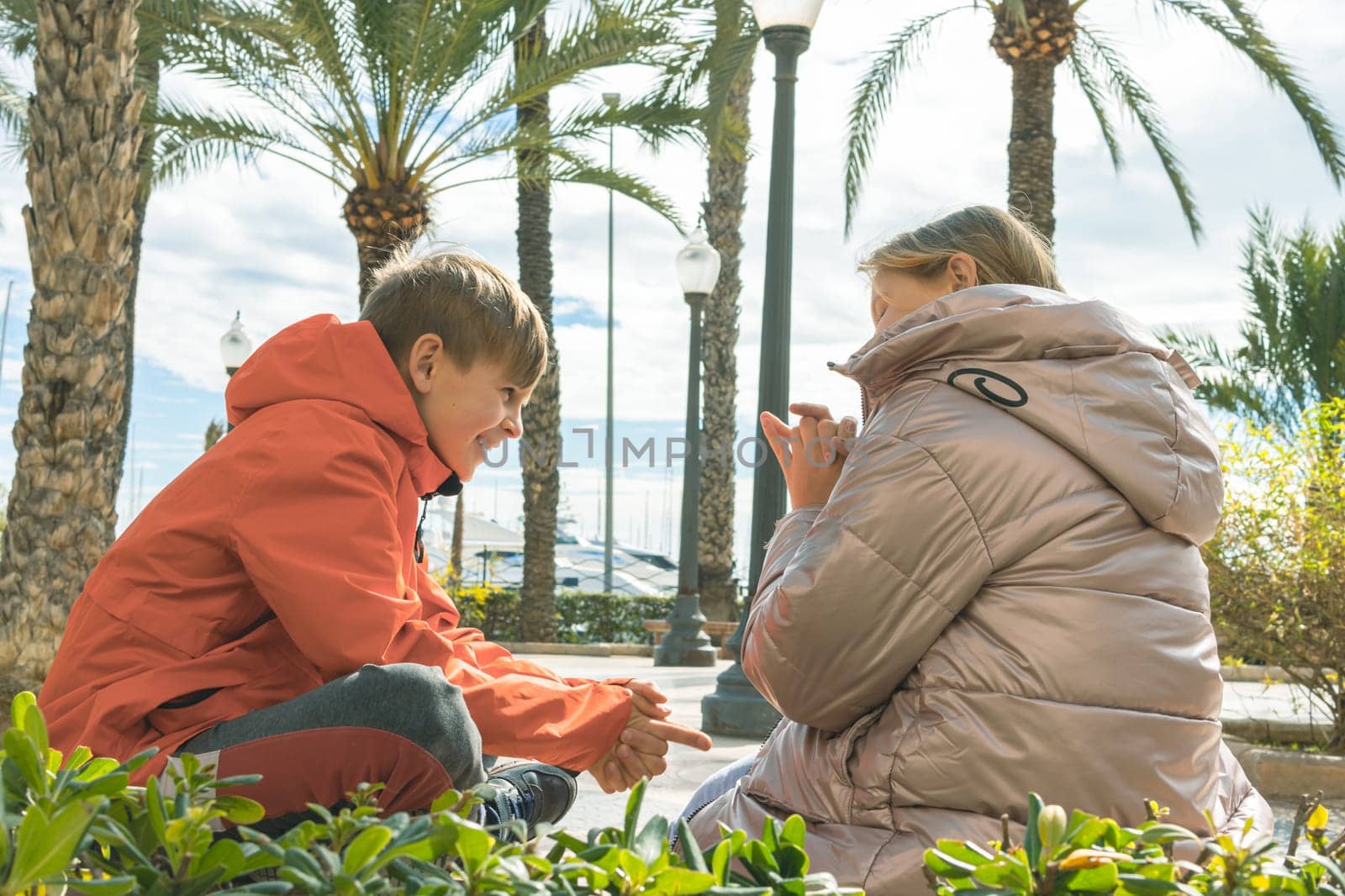 happy children sit on the embankment play while sitting on a bench. High quality photo