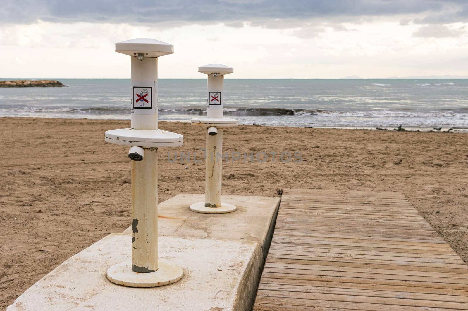 Old taps on the beach to rinse your feet from the sand, an empty beach without people, there is a place for an inscription. High quality photo