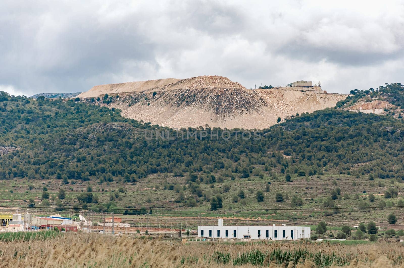 view of an open pit marble quarry showing heavy duty equipment and rock. High quality photo