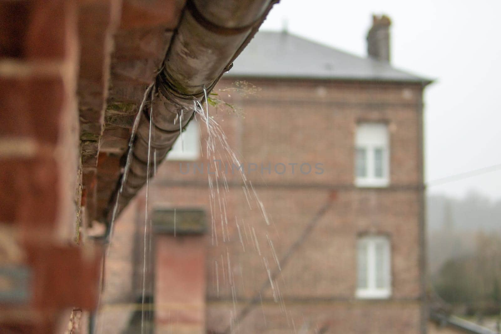 a gutter on a building, an old drainpipe close-up, water flows through rotten metal, there is a place for an inscription by PopOff