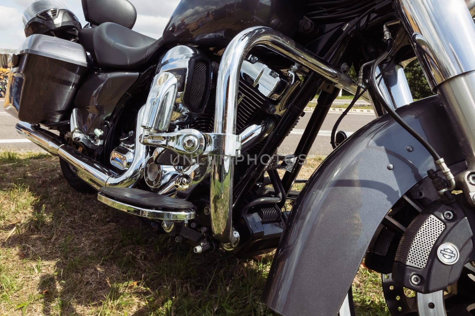 black motorcycle side view close-up ,motorcycle standing on green grass isolated,close-up view by PopOff