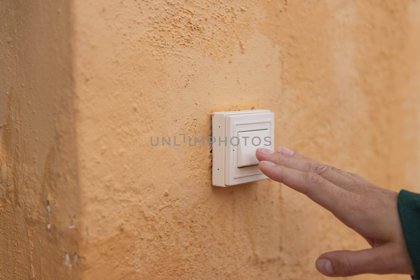 Female hand presses the doorbell button on the street close-up .there is a place for the inscription. High quality photo