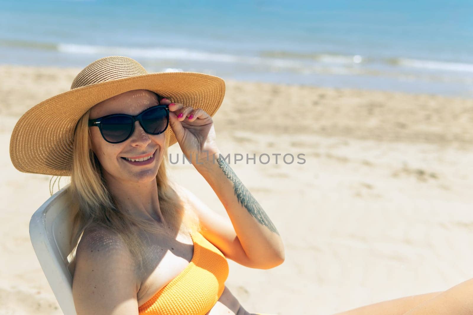 Smiling girl enjoys her vacation by the sea with copy space. The woman relaxes. High quality photo