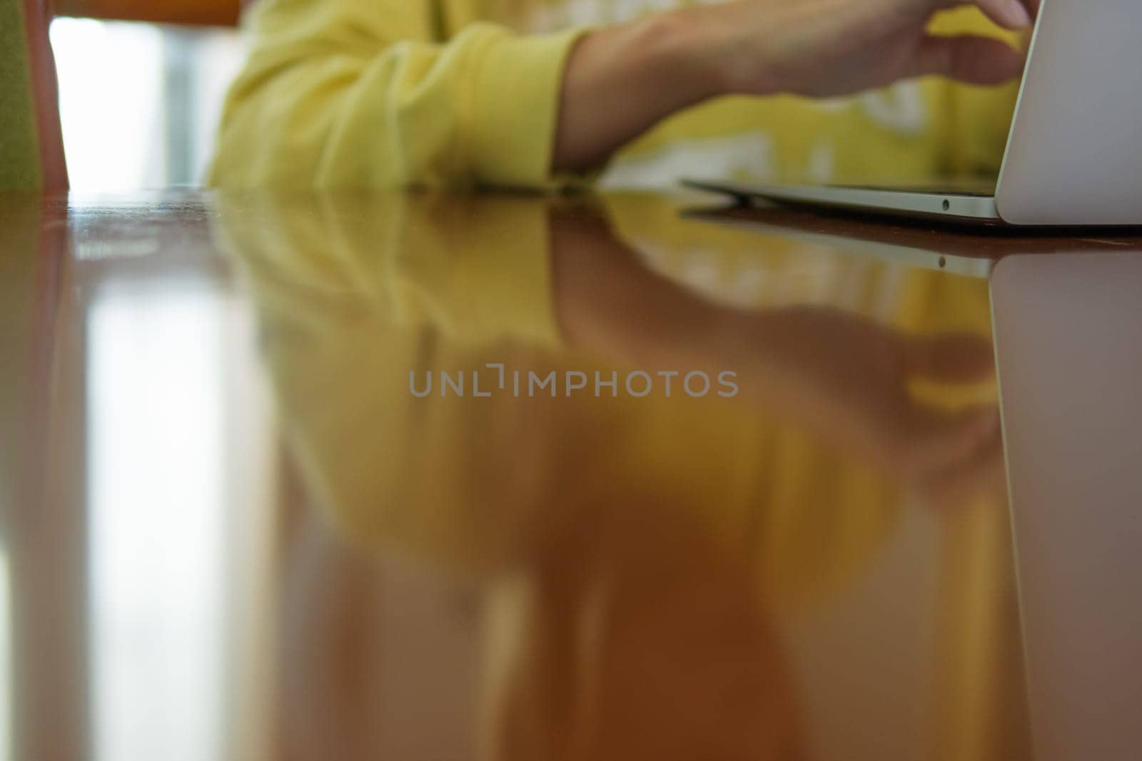close-up on the hands and laptop, the girl is sitting at the table and working in the laptop, there is a place for the inscription. High quality photo