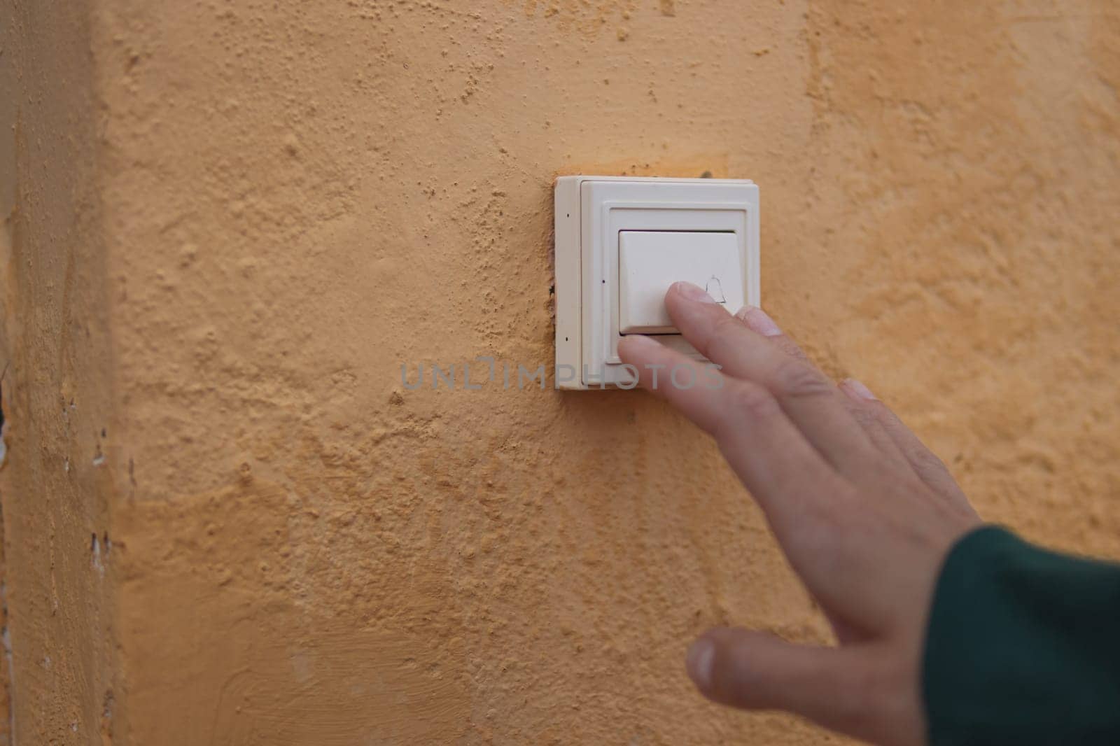 Female hand presses the doorbell button on the street close-up .there is a place for the inscription by PopOff