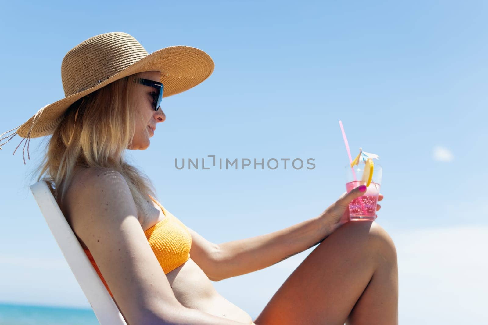 Smiling girl enjoys her vacation by the sea with copy space. The woman relaxes. High quality photo