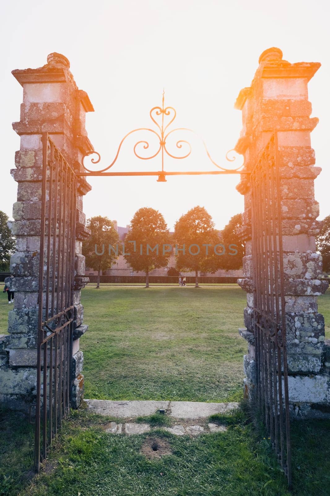 forged old gate close-up, the entrance to the castle, the gate was taken at sunset silhouette. A beautiful landscape has a place for an inscription by PopOff