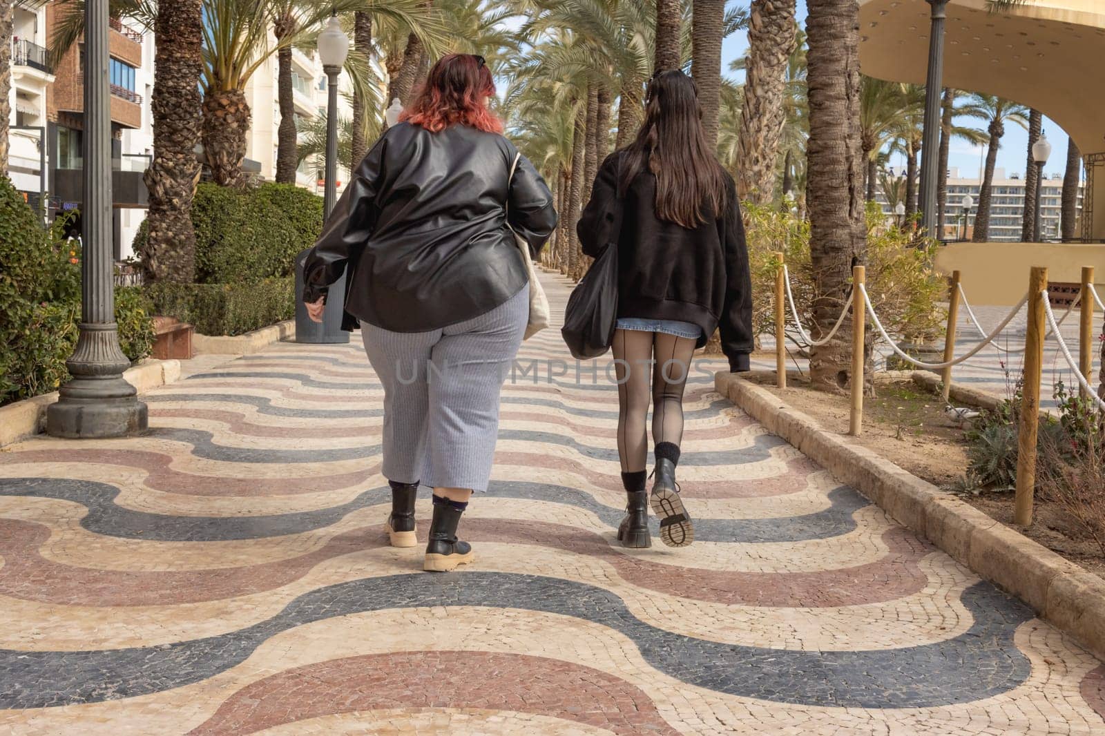 girls walk along the embankment, an overweight girl walks a lot with a thin girlfriend to lose weight. High quality photo