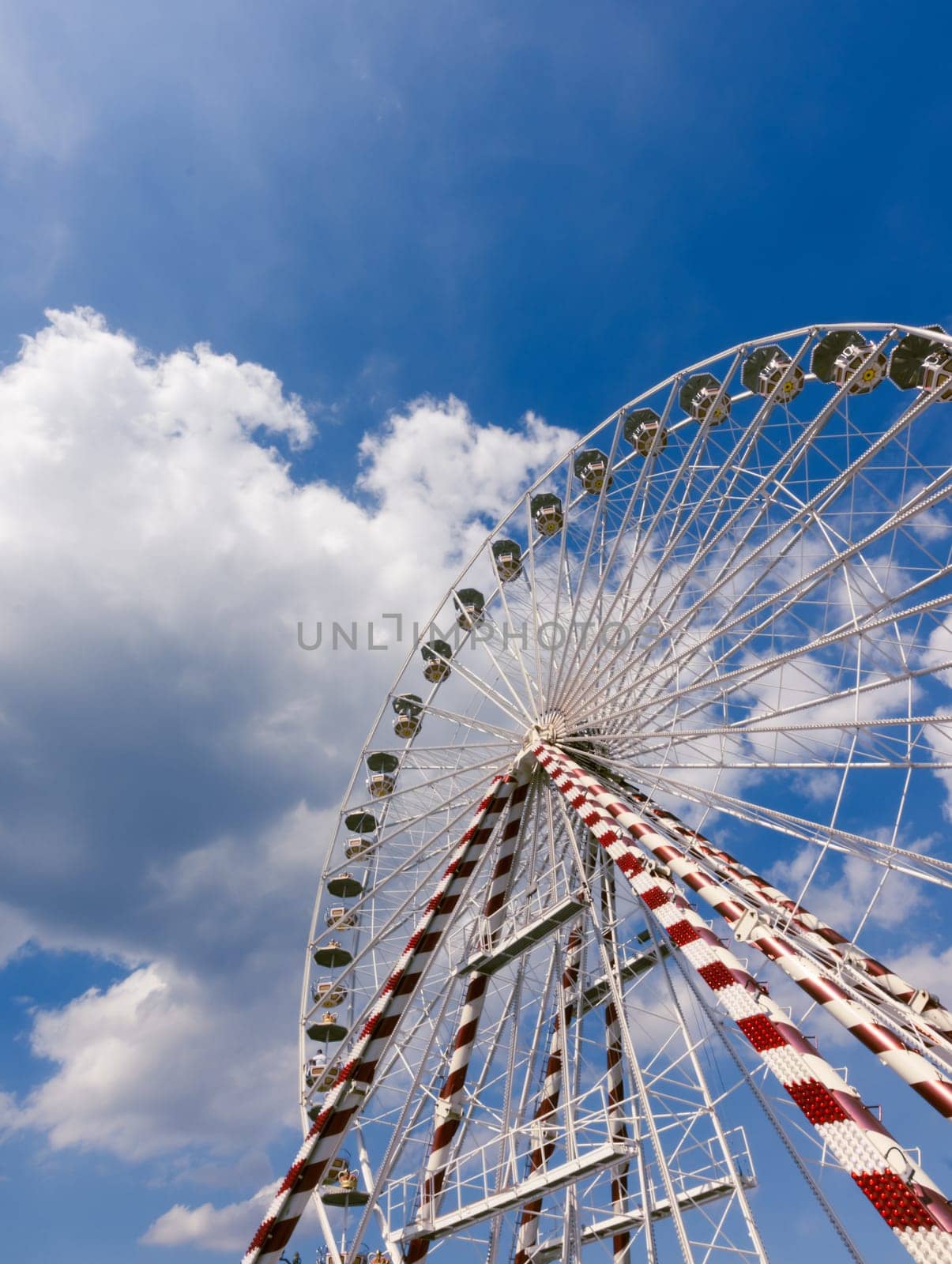 Ferris wheel in France in Honfleur, foreshortening from the bottom close-up against the blue sky.on the left there is a place for the inscription. High quality photo