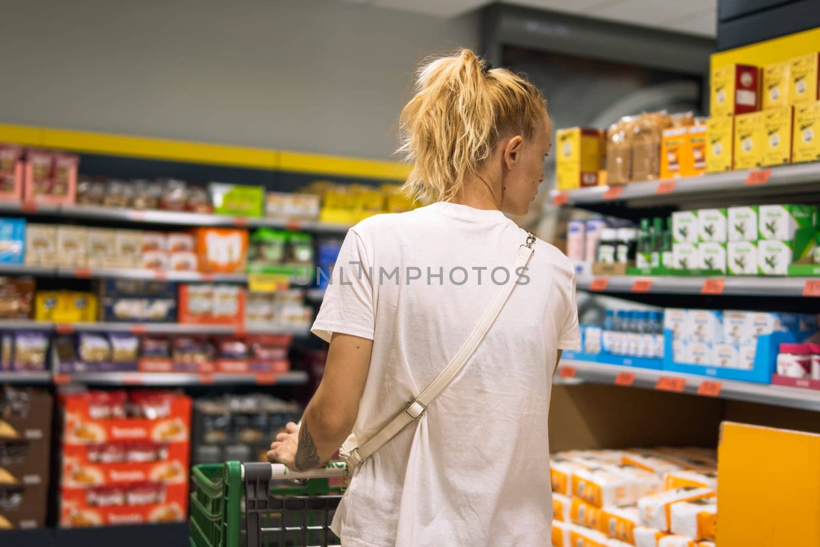 a fair-looking girl goes shopping and chooses groceries at home by PopOff