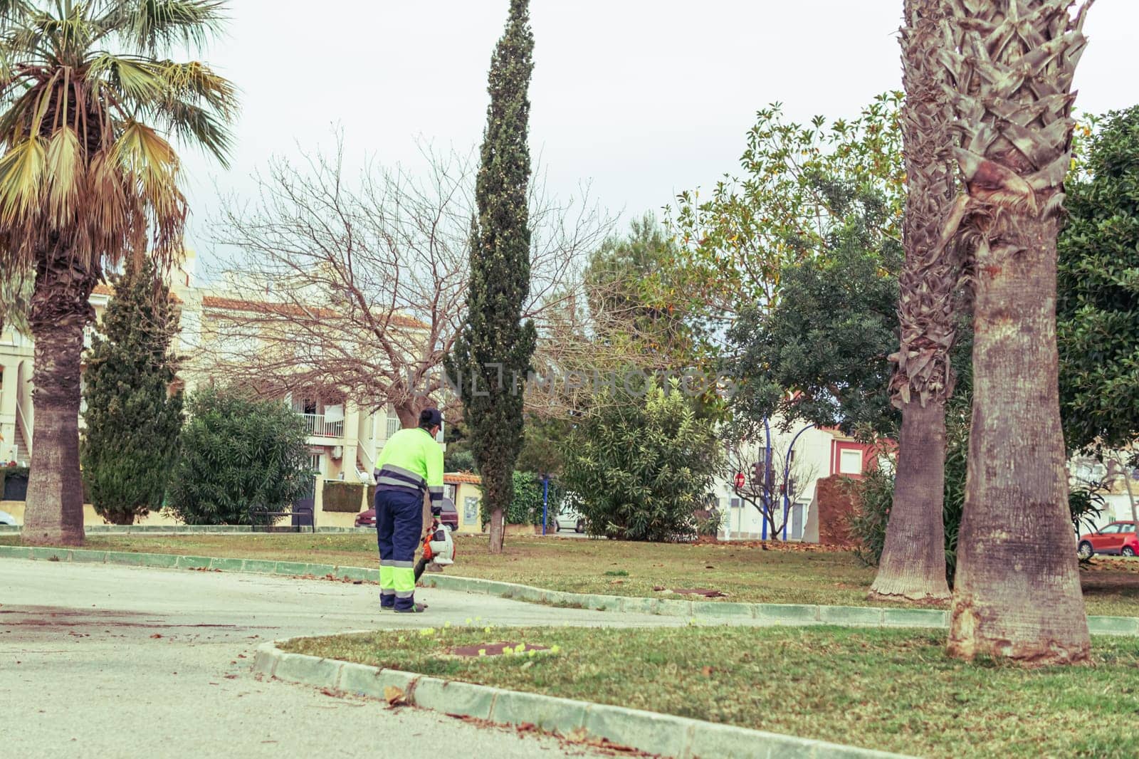 a girl in uniform cleans the streets with street cleaning equipment, a worker cleans the streets. High quality photo