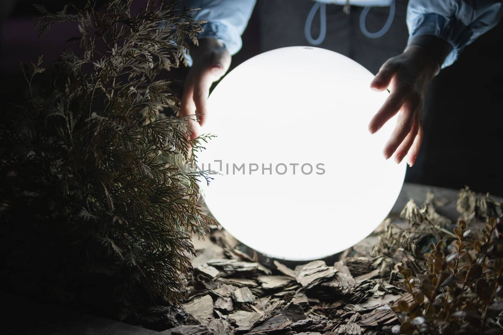 the girl holds a large luminous ball with her hands. The girl holds a luminous lantern. High quality photo