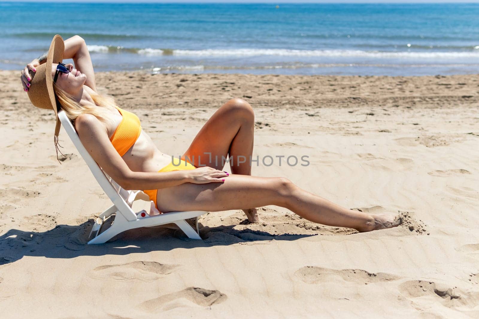 Smiling girl enjoys her vacation by the sea with copy space. The woman relaxes. High quality photo