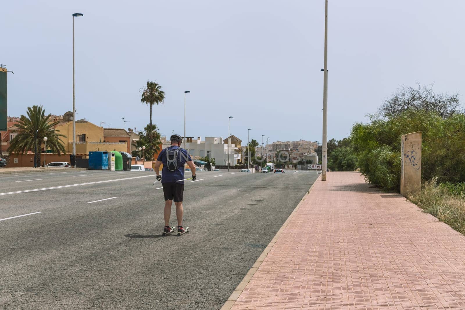 a man rollerblading down the road with his back to the camera by PopOff