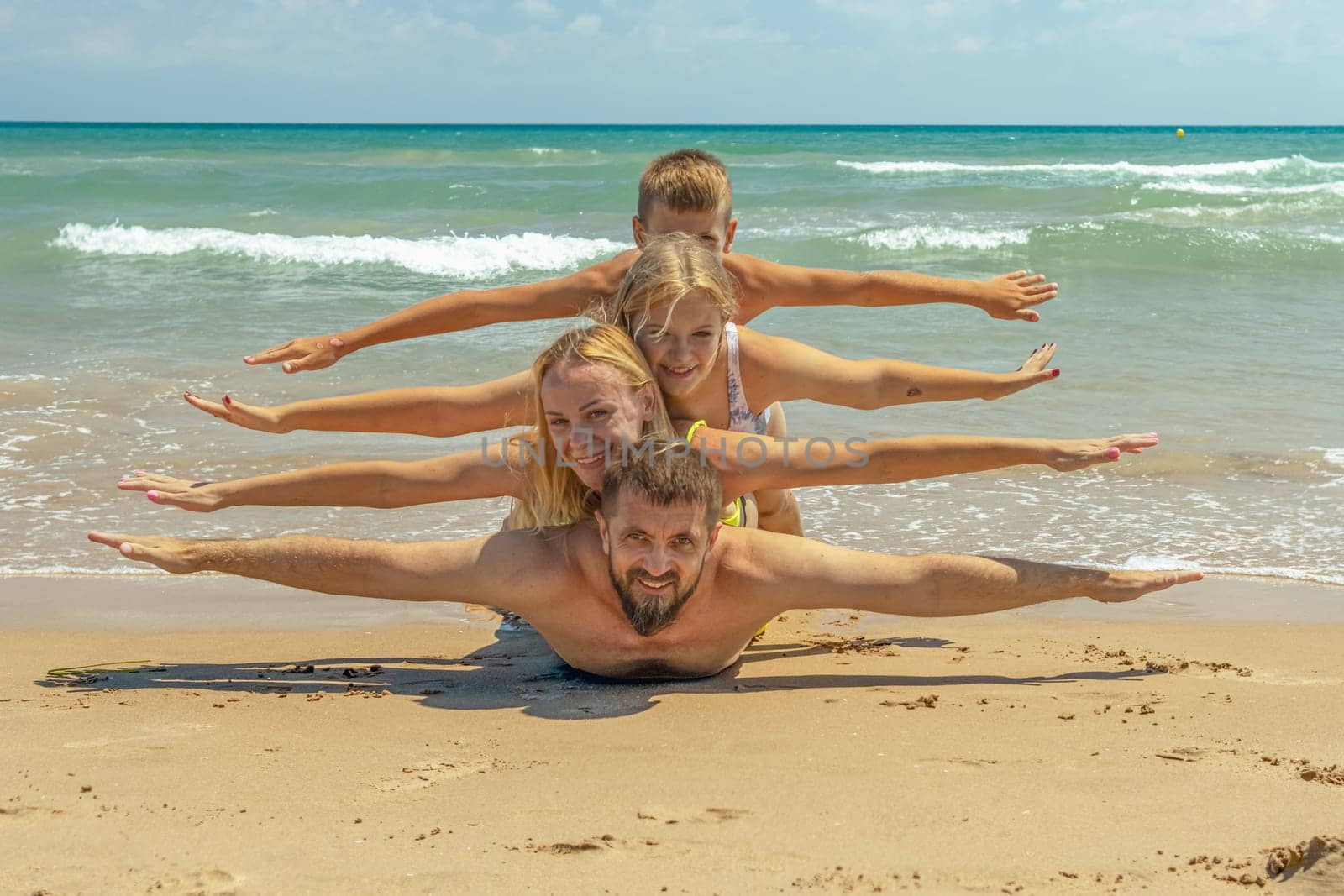happy family takes a creative photo on the seashore, mom, dad and two children take a photo on the seashore. High quality photo