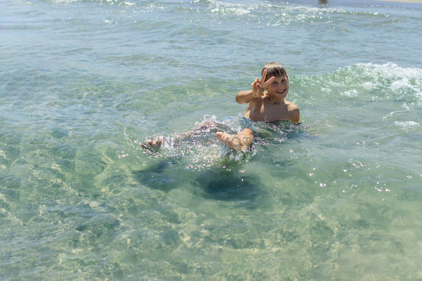 Happy boy swims and dives underwater. Active healthy lifestyle, water sports and activities with parents on summer family vacation with child. High quality photo
