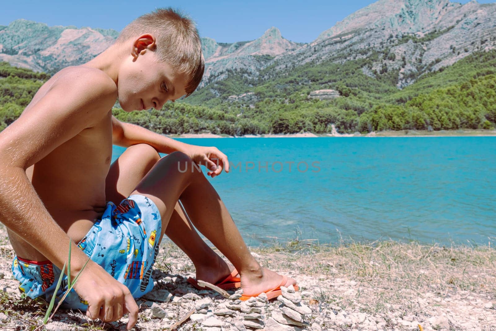 beautiful mountain landscape with a child against the backdrop of mountains and a lake. High quality photo