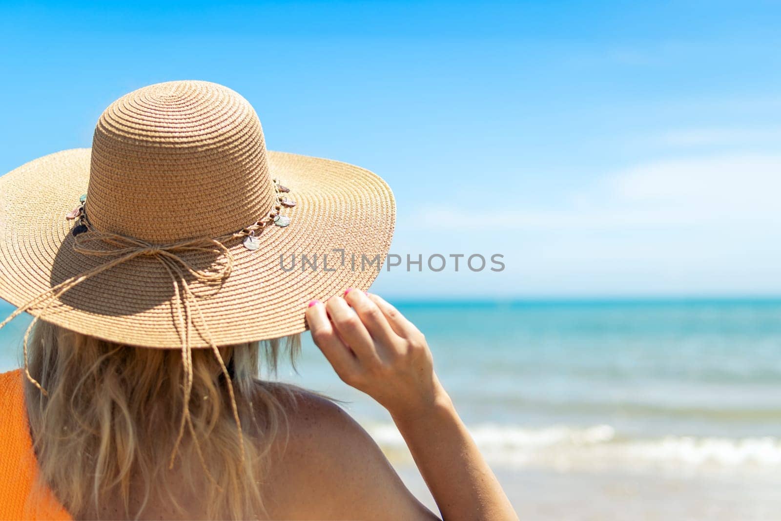 portrait of a girl with her back turned to the camera, close-up, the girl is standing in a brown hat and swimsuit, there is a place for an inscript. High quality photo