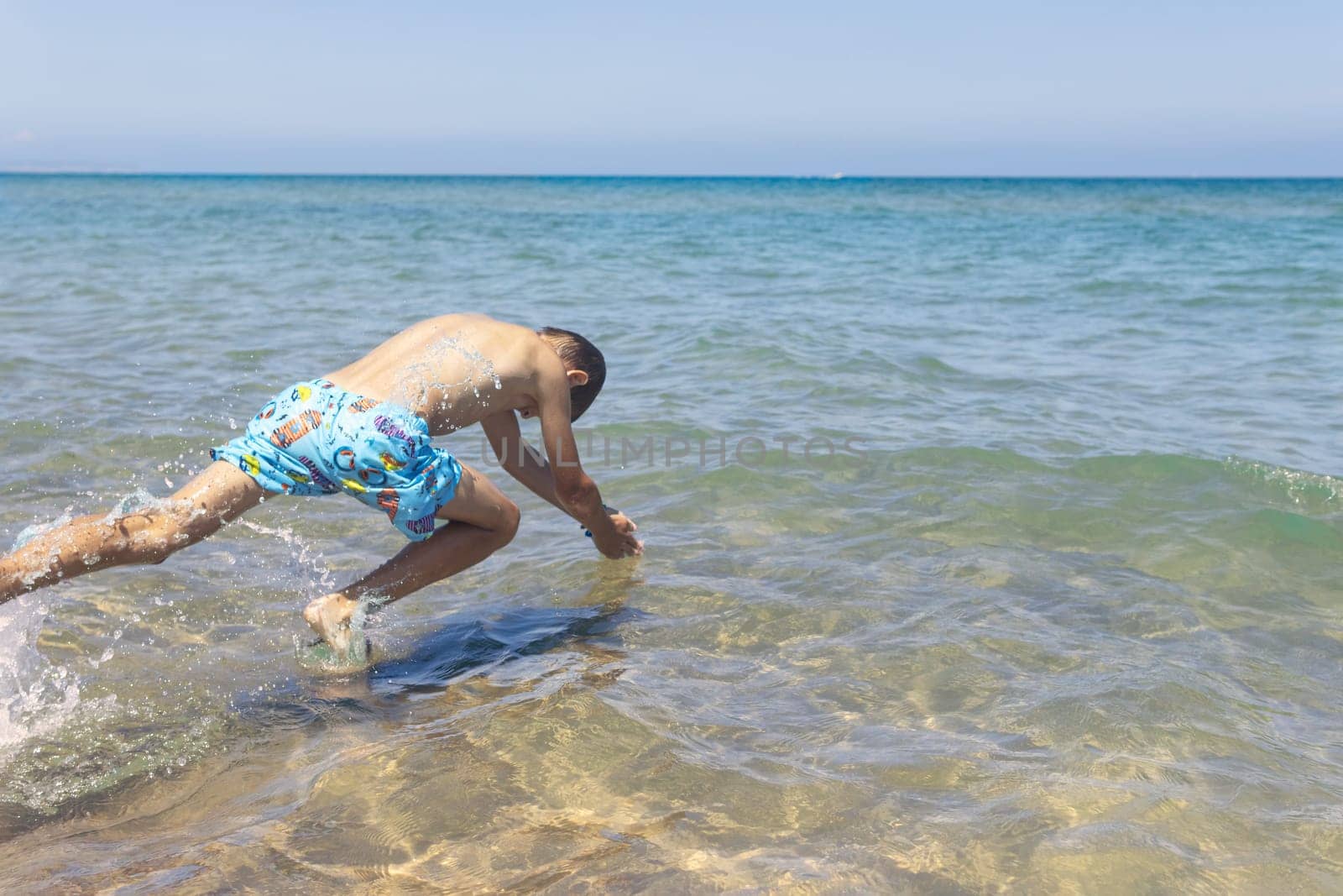 Happy boy swims and dives underwater. Active healthy lifestyle, water sports and activities with parents on summer family vacation with child. High quality photo