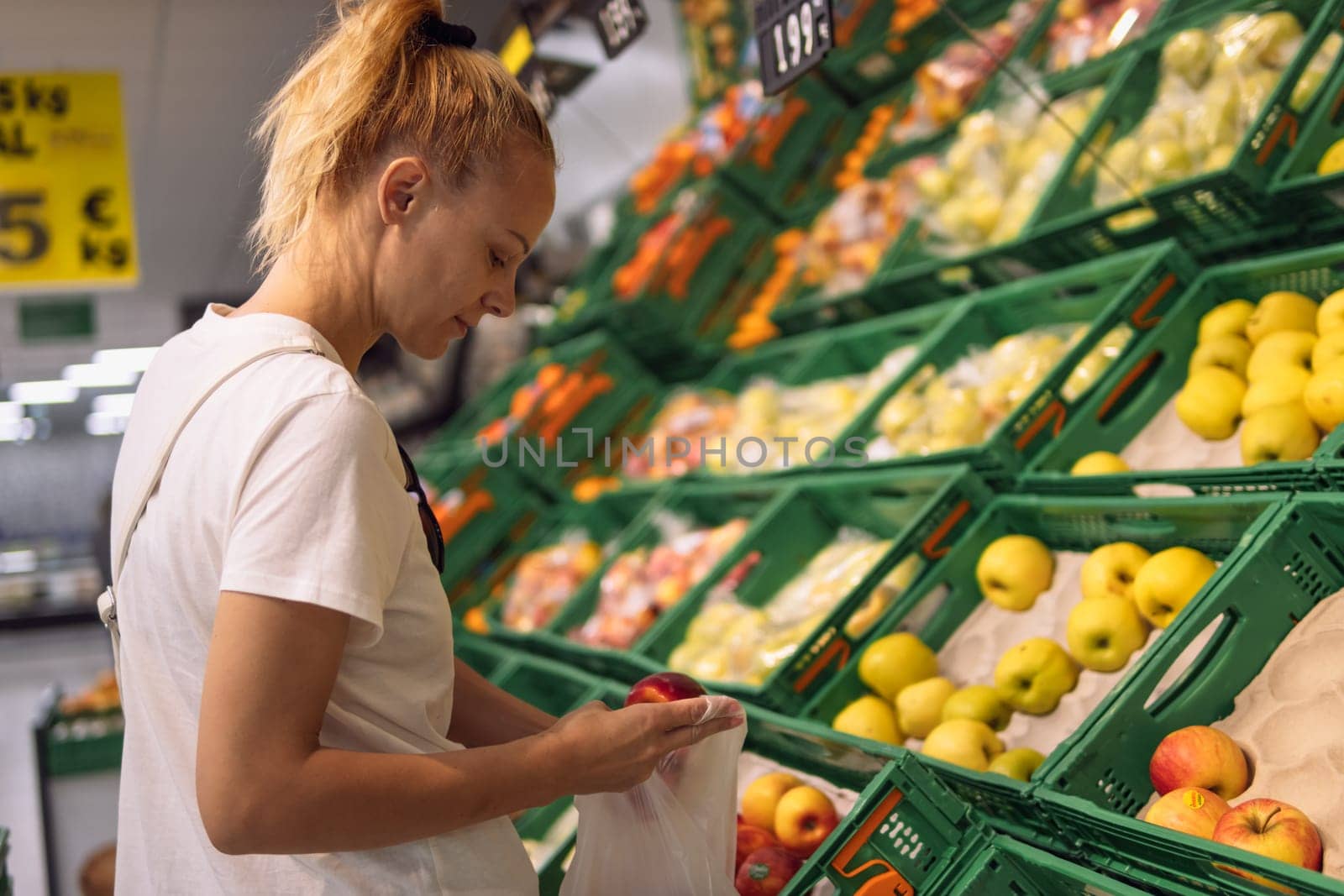 a girl of European appearance chooses fruits in a store, the concept of shopping home. High quality photo