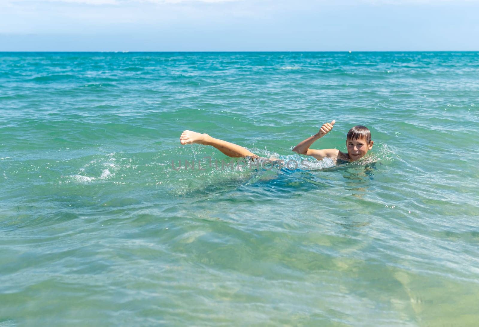 Happy boy swims and dives underwater. Active healthy lifestyle, water sports and activities with parents on summer family vacation with child. High quality photo