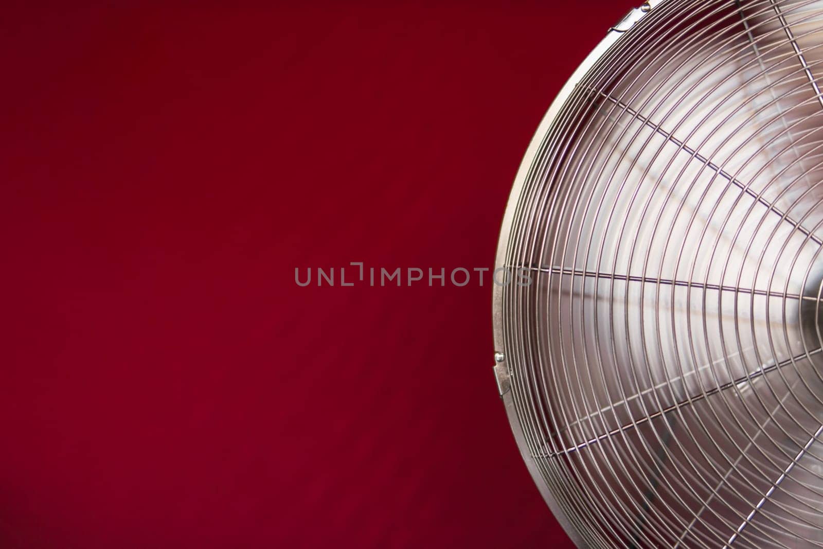 electric fan isolated on a red background, close-up on the left there is a place for an inscription by PopOff