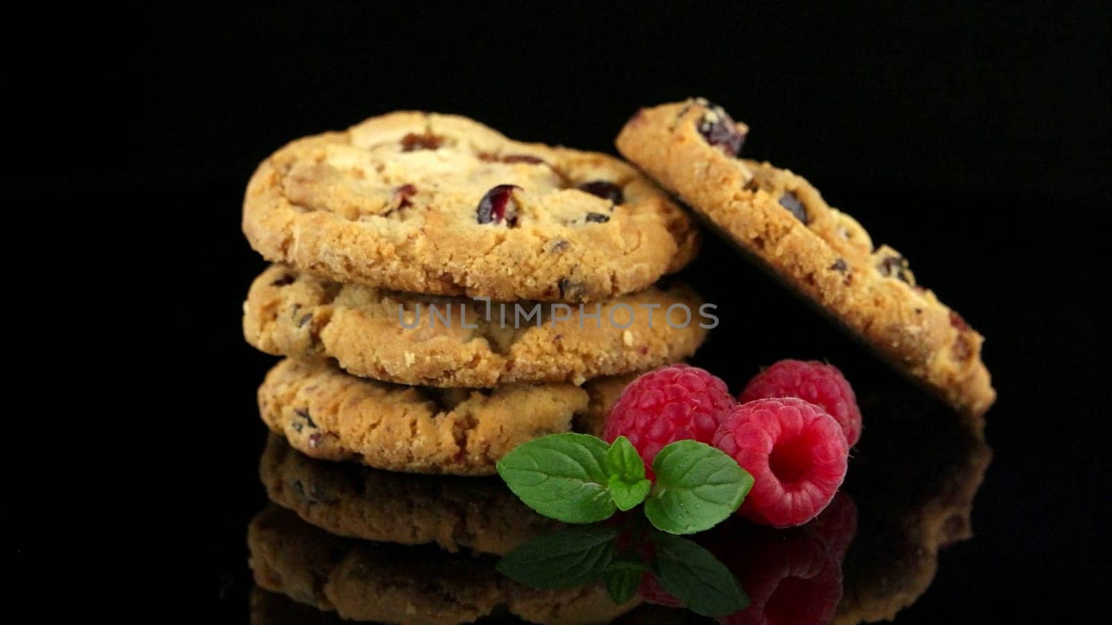 Dried fruits chip cookies and raspberries isolated on black background.