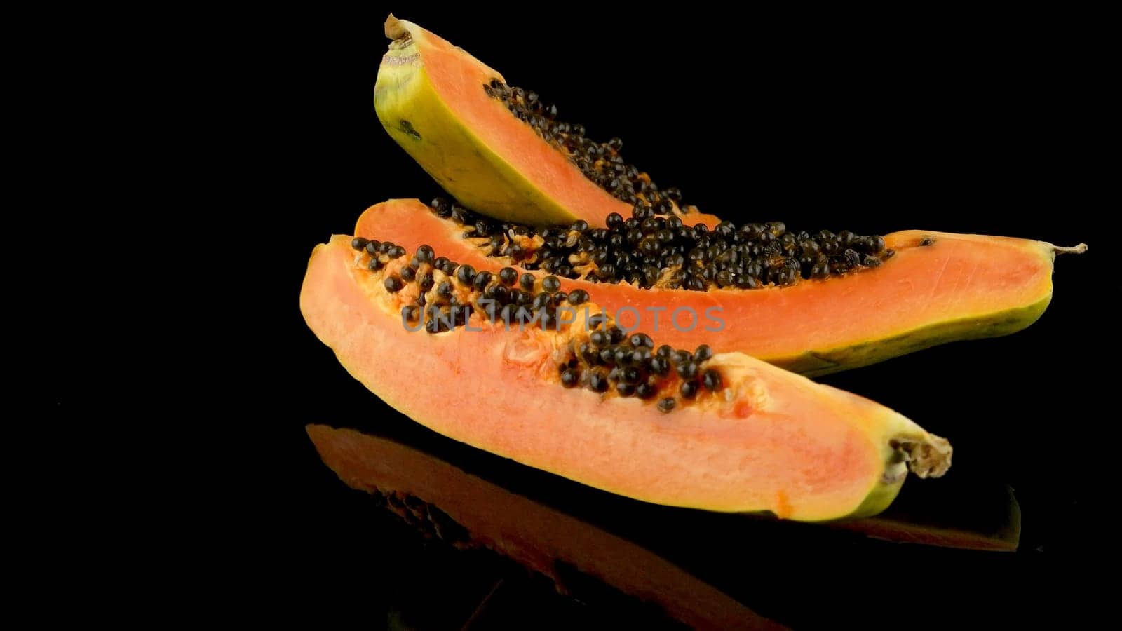 Slices of sweet papaya on black background.