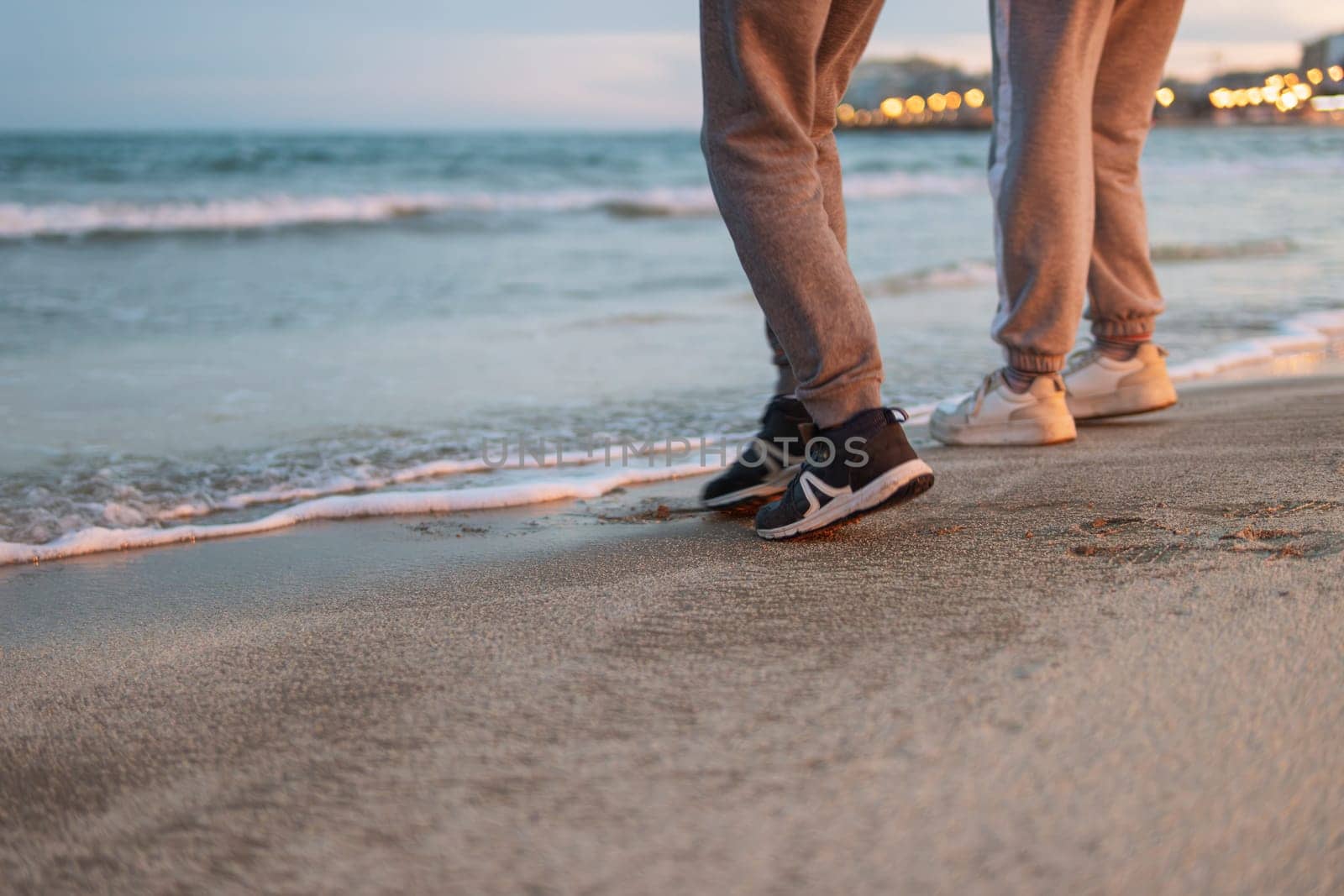 close-up of children's feet on the beach near the sea are standing.beautiful seascape with people. High quality photo