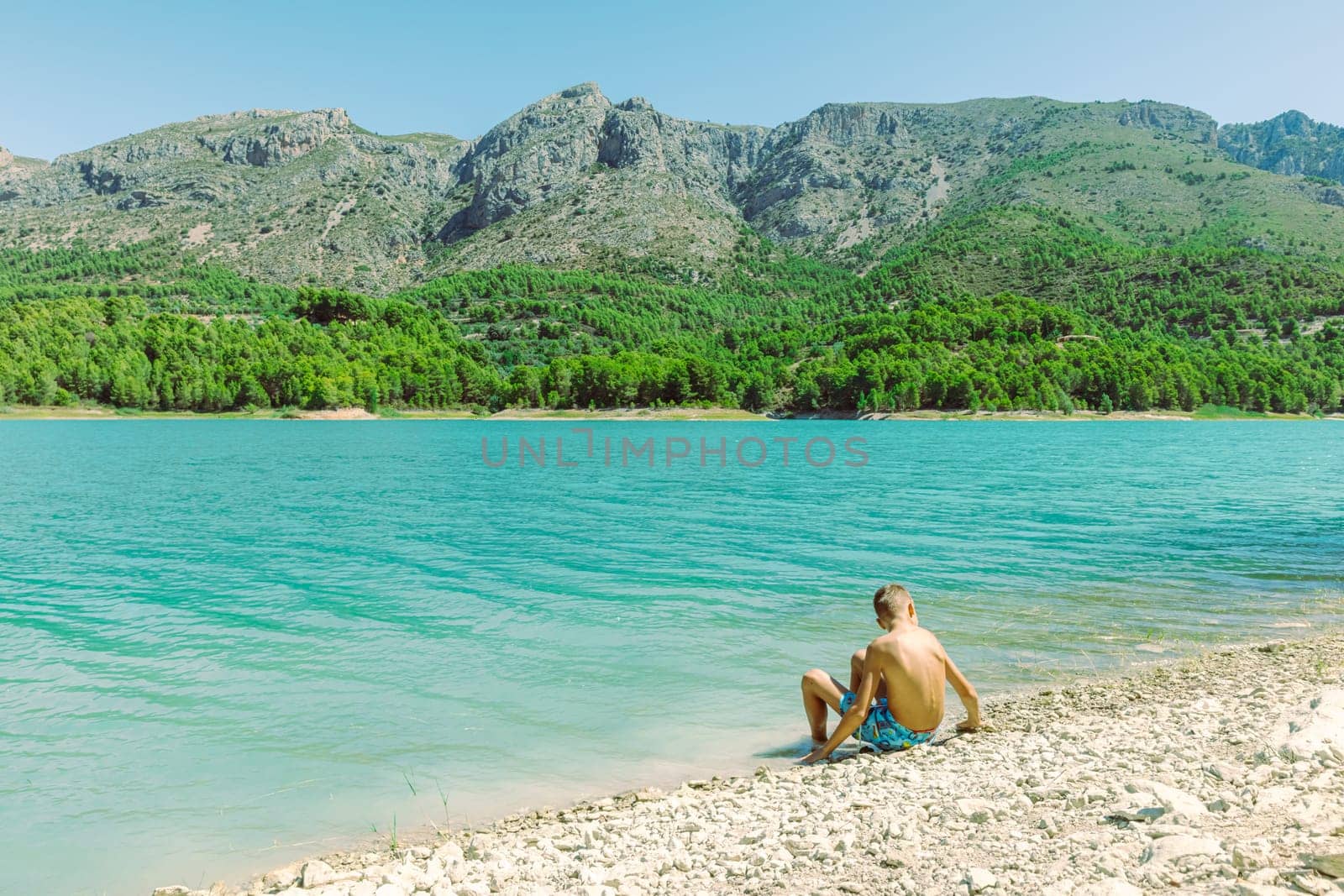 beautiful mountain landscape with a child against the backdrop of mountains and a lake. High quality photo