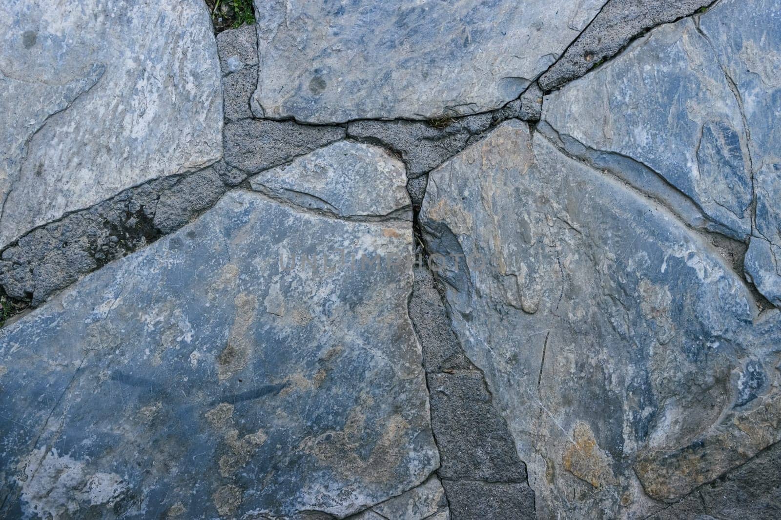 do-it-yourself road made with stones of various shapes on cement, macro shot. High quality photo