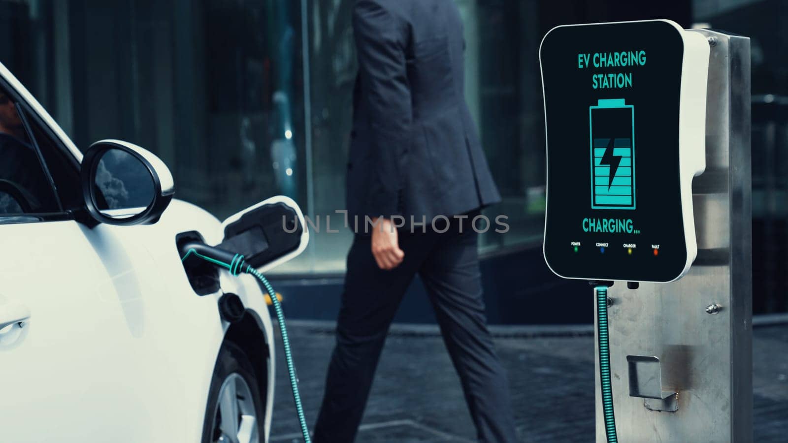 Businessman recharge his electric car from charging station. Peruse by biancoblue