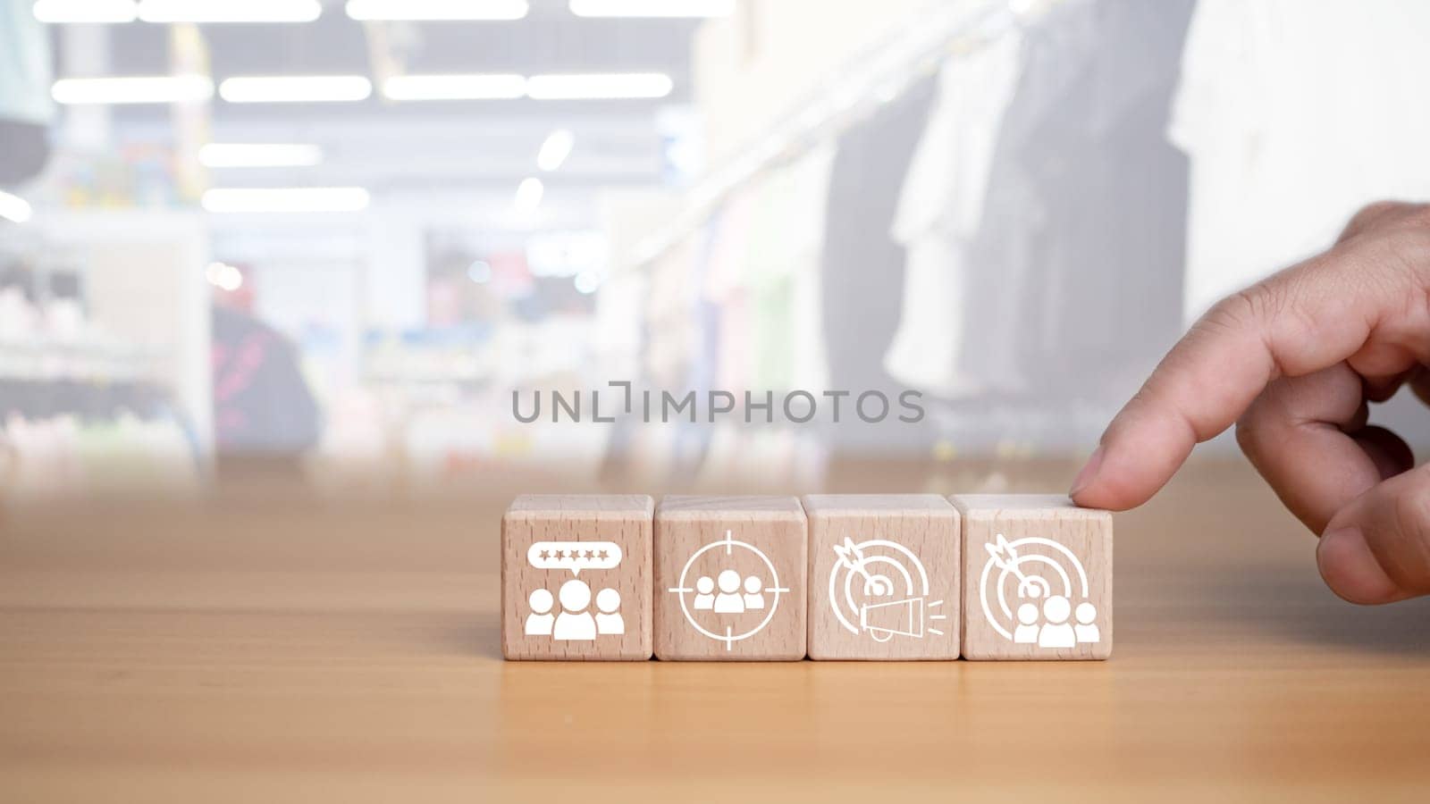 Human hands hold target customer icons on circle wooden planks. Placed on a wooden background, it represents selected business goals, target customers, marketing plans and strategies including customer-centric strategies.